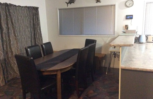 Rangiputa Haus | 1 Minute zu Fuß zum Strand und zur Rampe. Offene Lounge, Esszimmer und Küche.