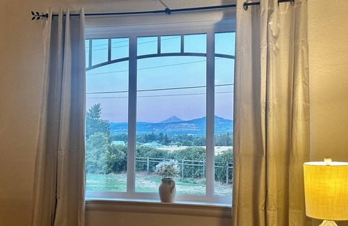 Medford Hütte | Wake to breathtaking sunrises over the rolling hills! Relax by the fire under the stars, & savor sunset dinners beneath fragrant wisteria pergola. Surrounded by wineries and minutes from historic Jacksonville, this retreat blends charm & convenience