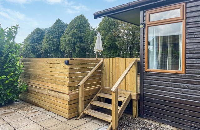 Renovated lodge with hot tub sunken into the new decking and outdoor rattan furniture.