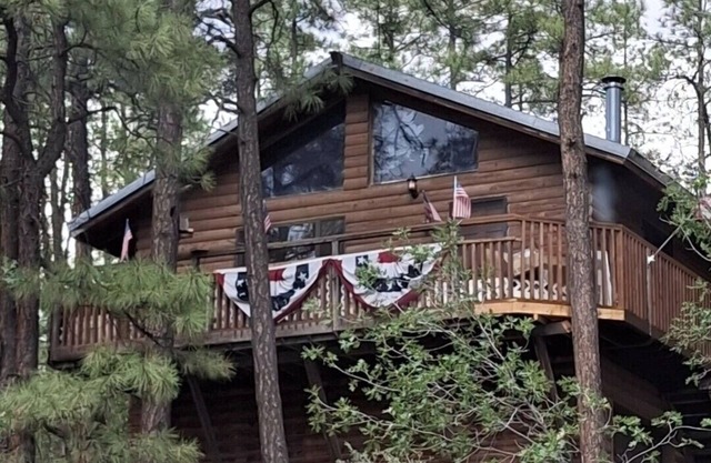 A centrally located secluded mountainside log cabin w/ panoramic valley views.