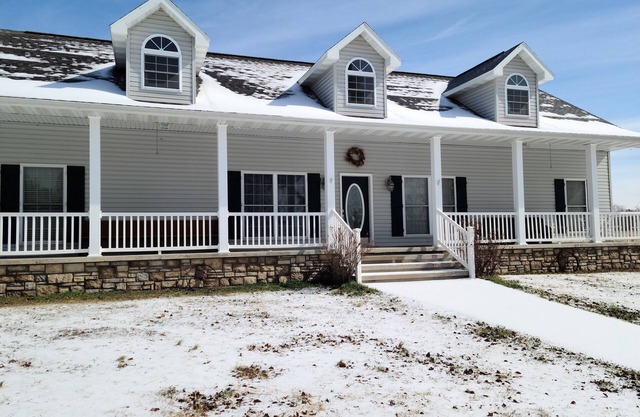 A large country home with scenic views of a working cattle farm & rural locale.