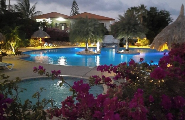 Ein kleiner Palast mit riesigen Swimmingpool im tropischen Garten