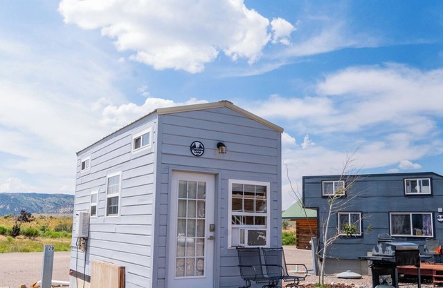 Adorable Tiny Home with two lofts. Both are accessible by ladder. One has a Queen mattress and the other has a Twin mattress. Home also contains a folding Full futon on main level. Sleeps: 4