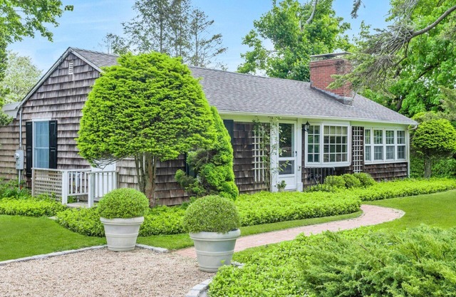 Beautiful cottage on meticulously maintained lawn, surrounded by...