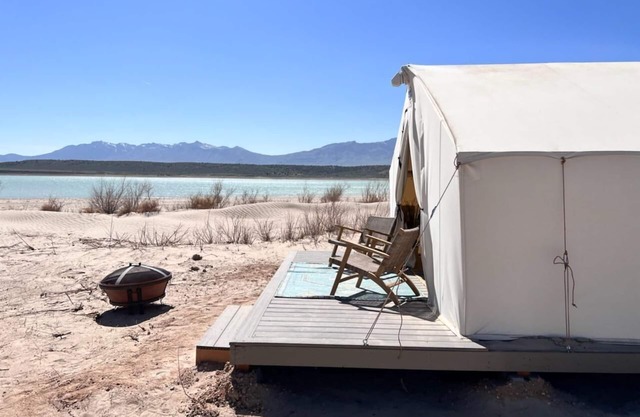 Beautiful wall tent on sandy beach at waters edge