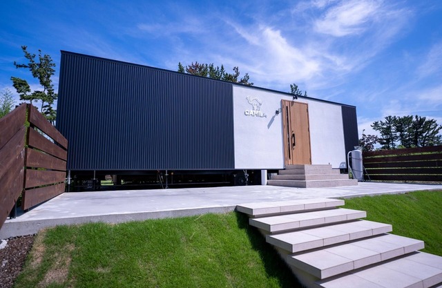 A large lawn and wooden deck spread out in a priva / Makinohara Shizuoka