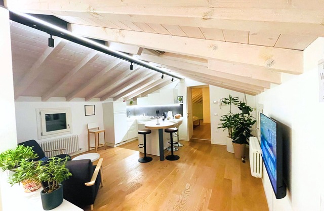 Casa Tonde, a modern attic with exposed beams.