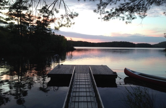 Megunticook lakefront camp in Camden, Maine with large porch, dock & boats