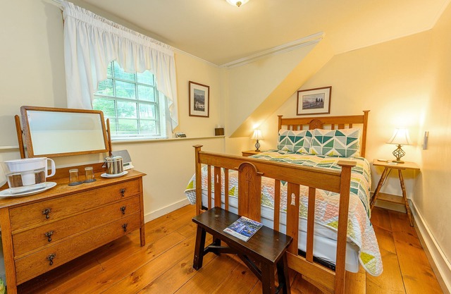 Comfortable budget room with queen bed, street view, and all-glass shower stall with full service breakfast included