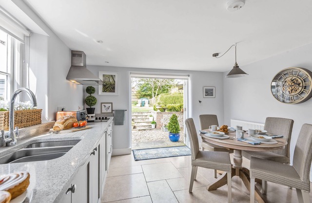 Thatched and built of local brick and flint, Coombe Cottage is a stylish Grade II listed cottage, bu