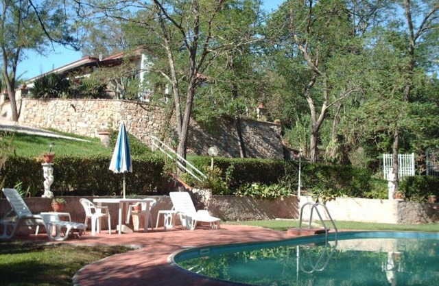 Detached cottage in a park-like garden overlooking the pool