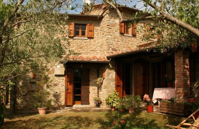 Ganz freistehendes und umzäuntes Steinhaus mit einer Veranda. Der Garten ist mit Tisch, Stühlen und