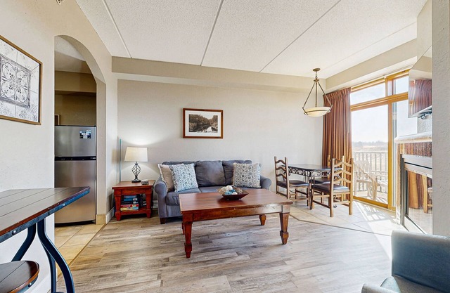 Golf-front modern condo with fireplace, balcony, & golf course views