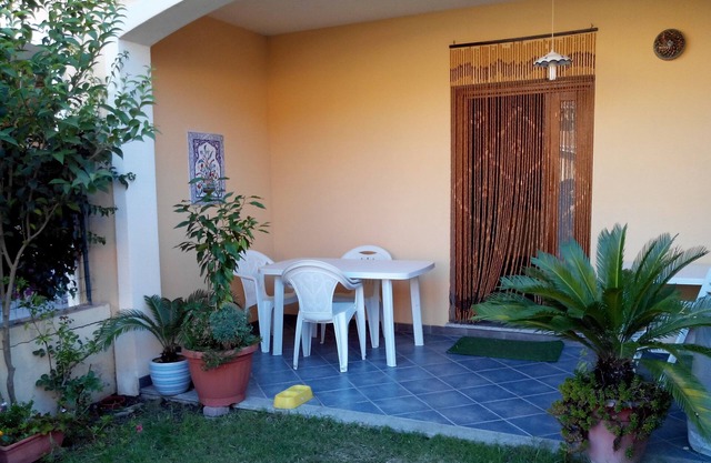 Haus im Erdgeschoss mit zwei kleinen Gärten und überdachter Veranda