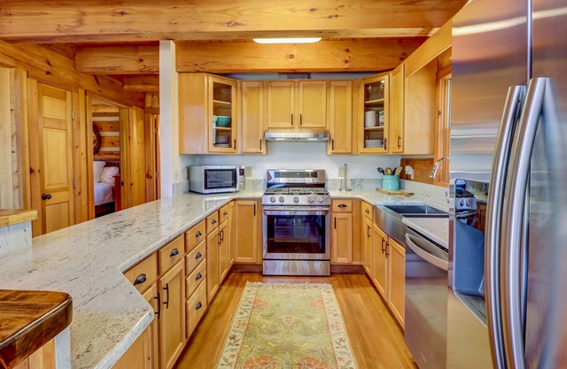 Log cabin in private community with stone fireplace & wrap-around porch