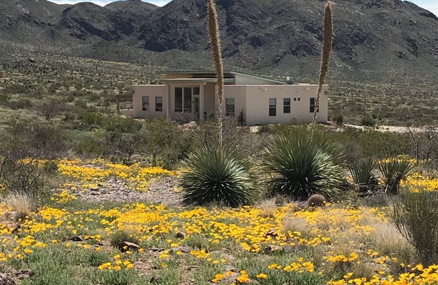 Modern home boarding desert wilderness and National Organ Mountain Monument .