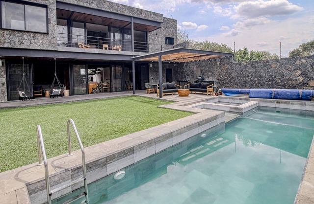 Modern home with a private pool, hot tub, outdoor kitchen, & mountain views
