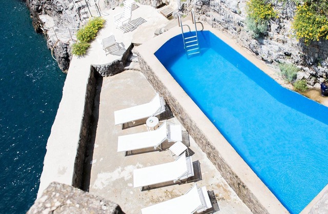 Ein Turm am Meer mit einem privaten Bootssteg und einem Meerwasserpool
