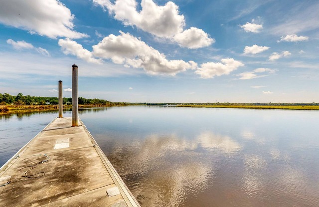 Palm-lined home with dock access, firepit & inviting balconies