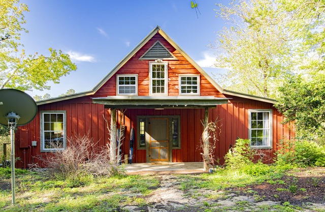 Private cabin built over a lake with a large breezy screened-in porch.