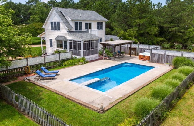 Gehobenes Cottage am Wasser mit einem Pool und Whirlpoolfüßen von der Hintertür.