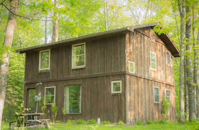 Rustikal Zwei Ebene Tree Lodge Durch den Wald mit Umgeben Kamin und Feuerstelle