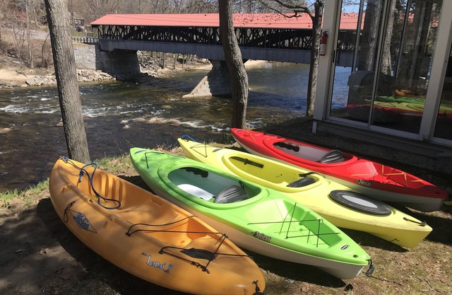 Bleiben Sie auf dem Saco River neben einer überdachten Brücke