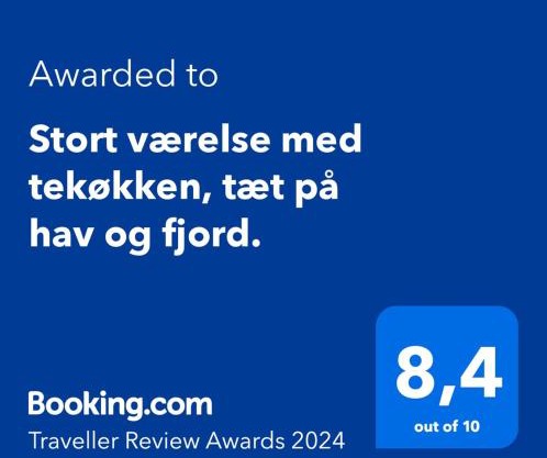 Stort værelse med tekøkken, tæt på hav og fjord.