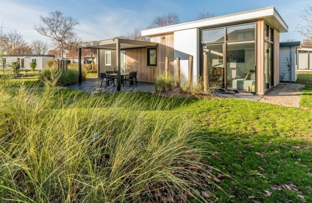 Dieses Chalet ist von einem geschützten Garten mit Dünen, Strandhafer und einer Baumreihe umgeben. B