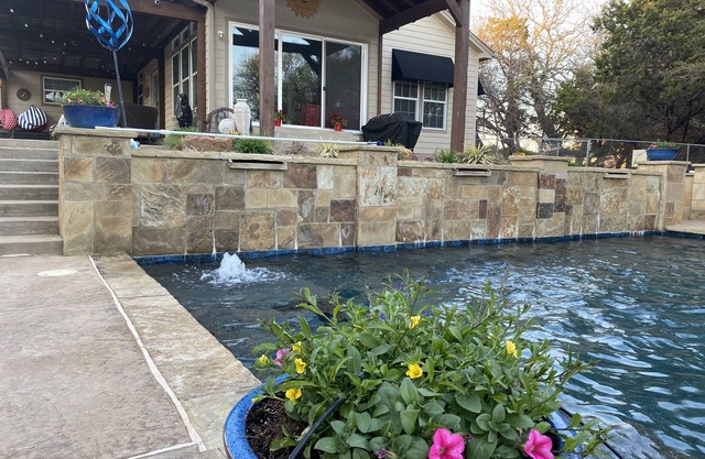Tranquil Waterfront property with a pool, hot tub & firepit.
