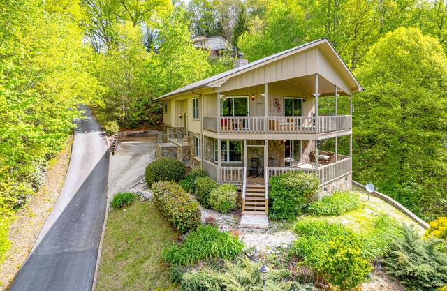 View-worthy home lined by trees with a fireplace, wrap-around deck, grill, & W/D