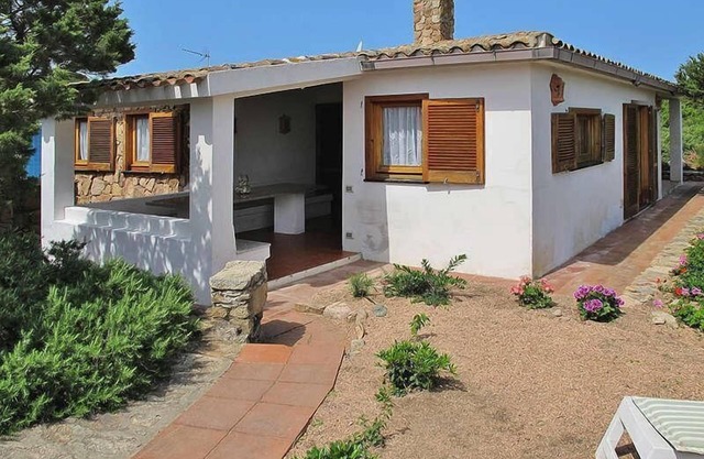 Villa einen kurzen Spaziergang vom Meer entfernt von einem Garten mit Bäumen, Pflanzen und Blumen