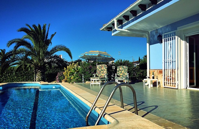 Villa with private pool, green blooming garden and palm near the beach