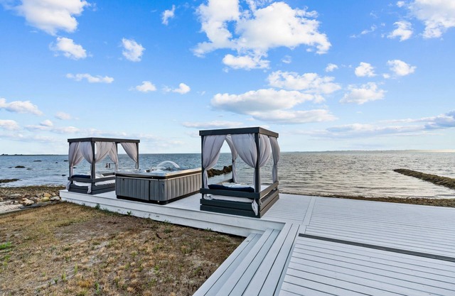 Waterfront Oasis with day beds and hot tub with captivating sunsets.
