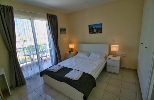 Peyia Town Haus | Direct access to the pool from the garden. A sandy beach is a few minutes away.