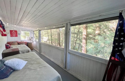 Greene Hütte | Rustic cottage surrounded by trees, overlooking a creek.