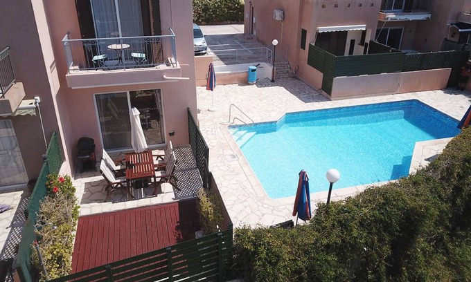Peyia Town Haus | Direct access to the pool from the garden. A sandy beach is a few minutes away.